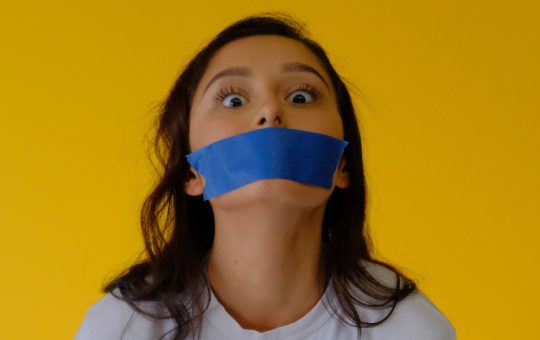 woman with tape over her mouth